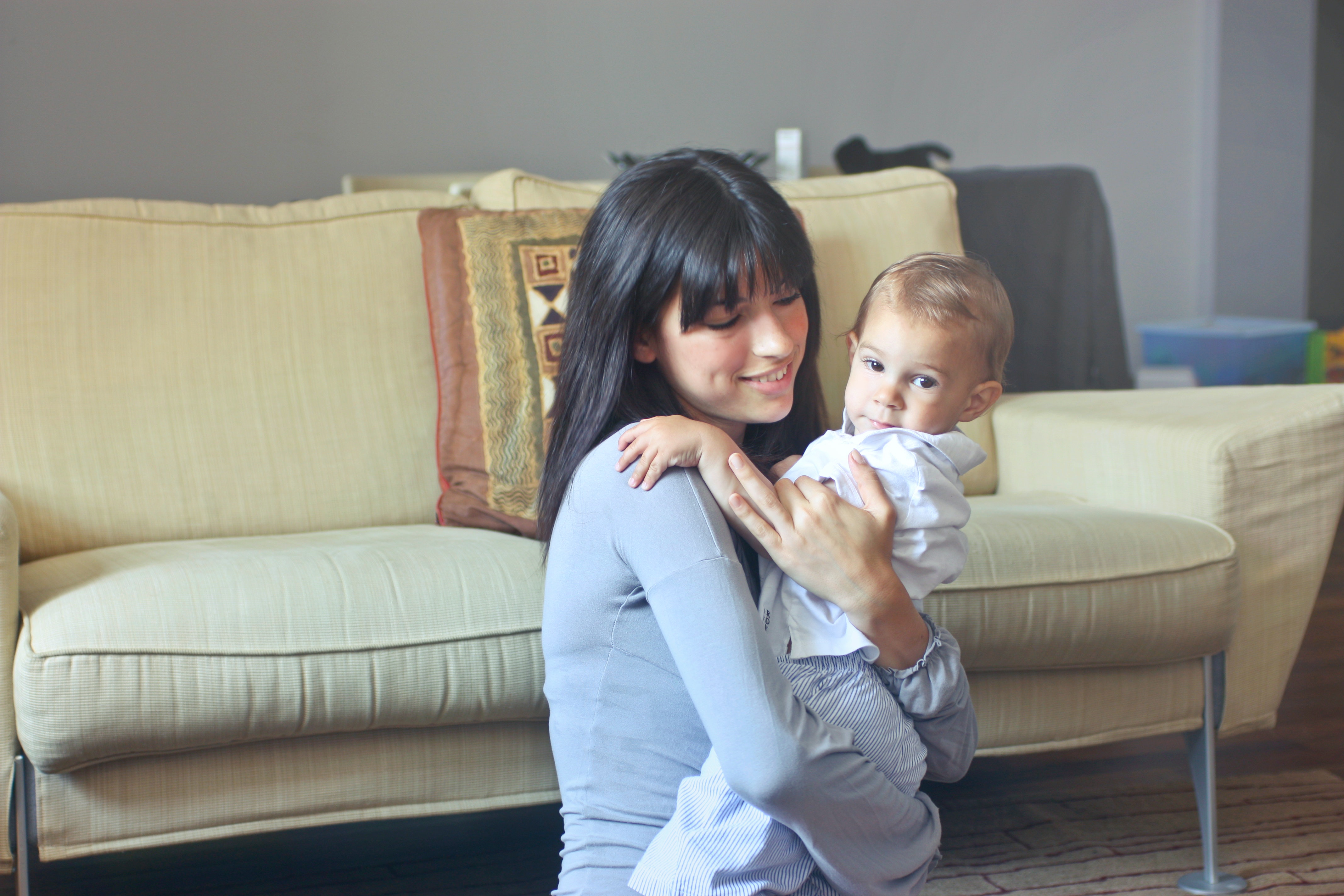 une baby-sitter auto-entrepreneur tient un enfant dans les bras