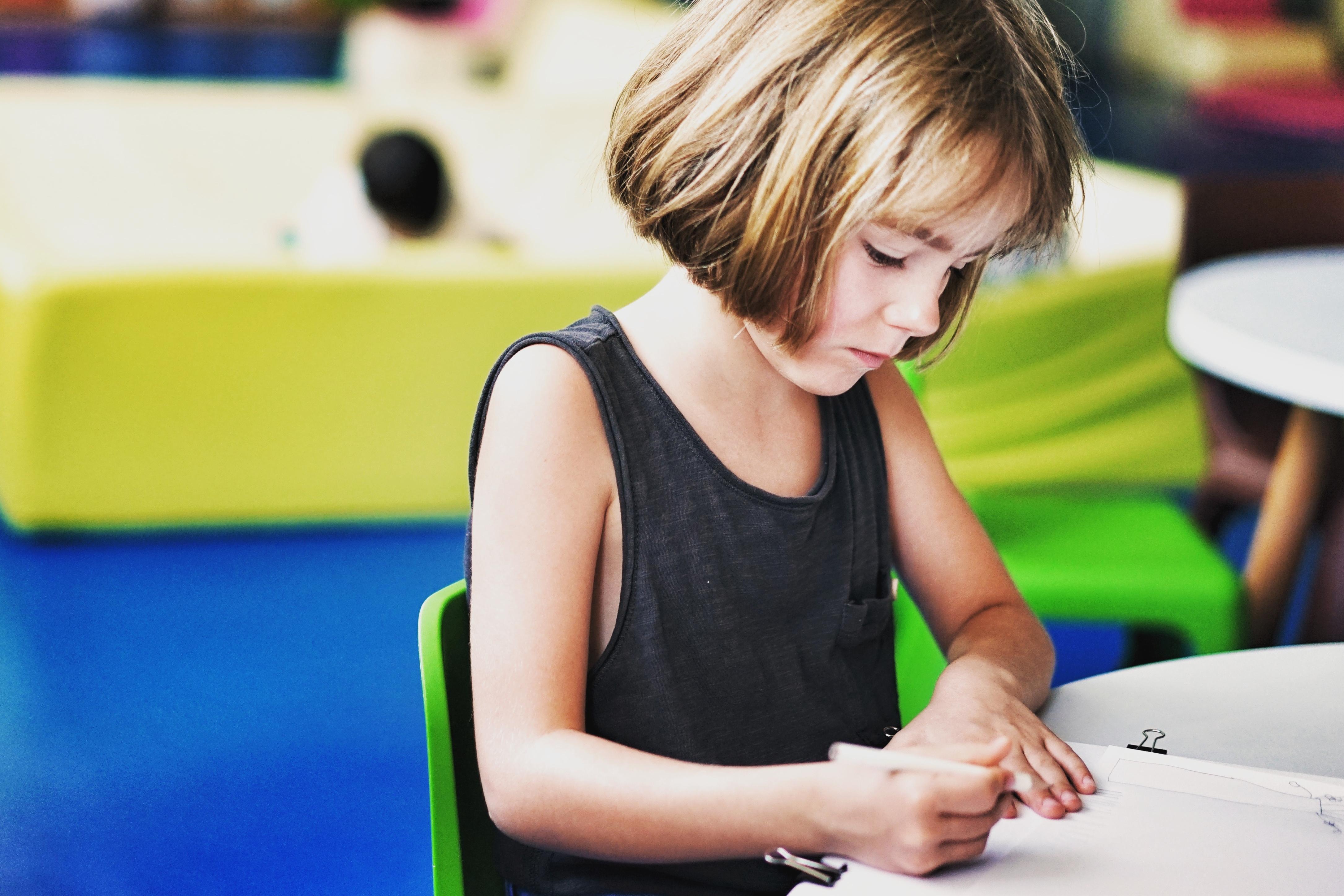 petite fille qui écrit pendant un babysitting
