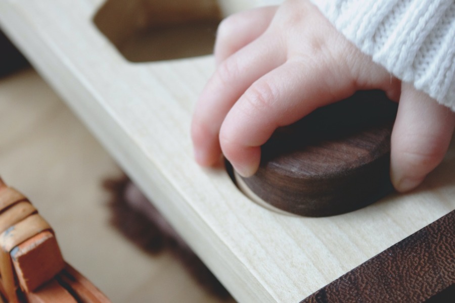 main d'enfant plaçant qui développe son autonomie avec un jeu montessori
