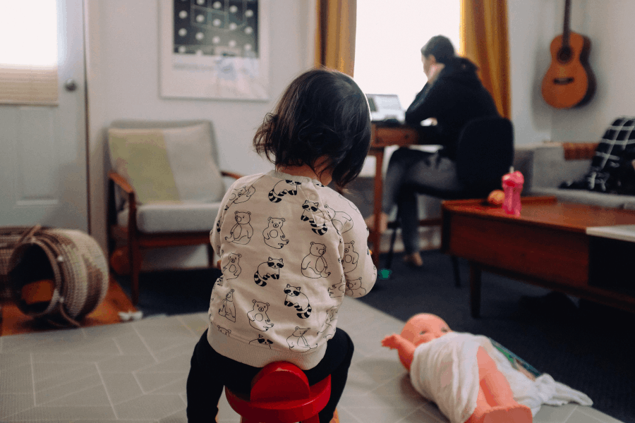 enfant sur un tabouret avec parents qui télétravail