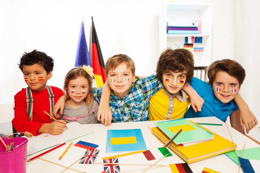 5 enfants parant différentes langues assit à une table / éveil aux langues