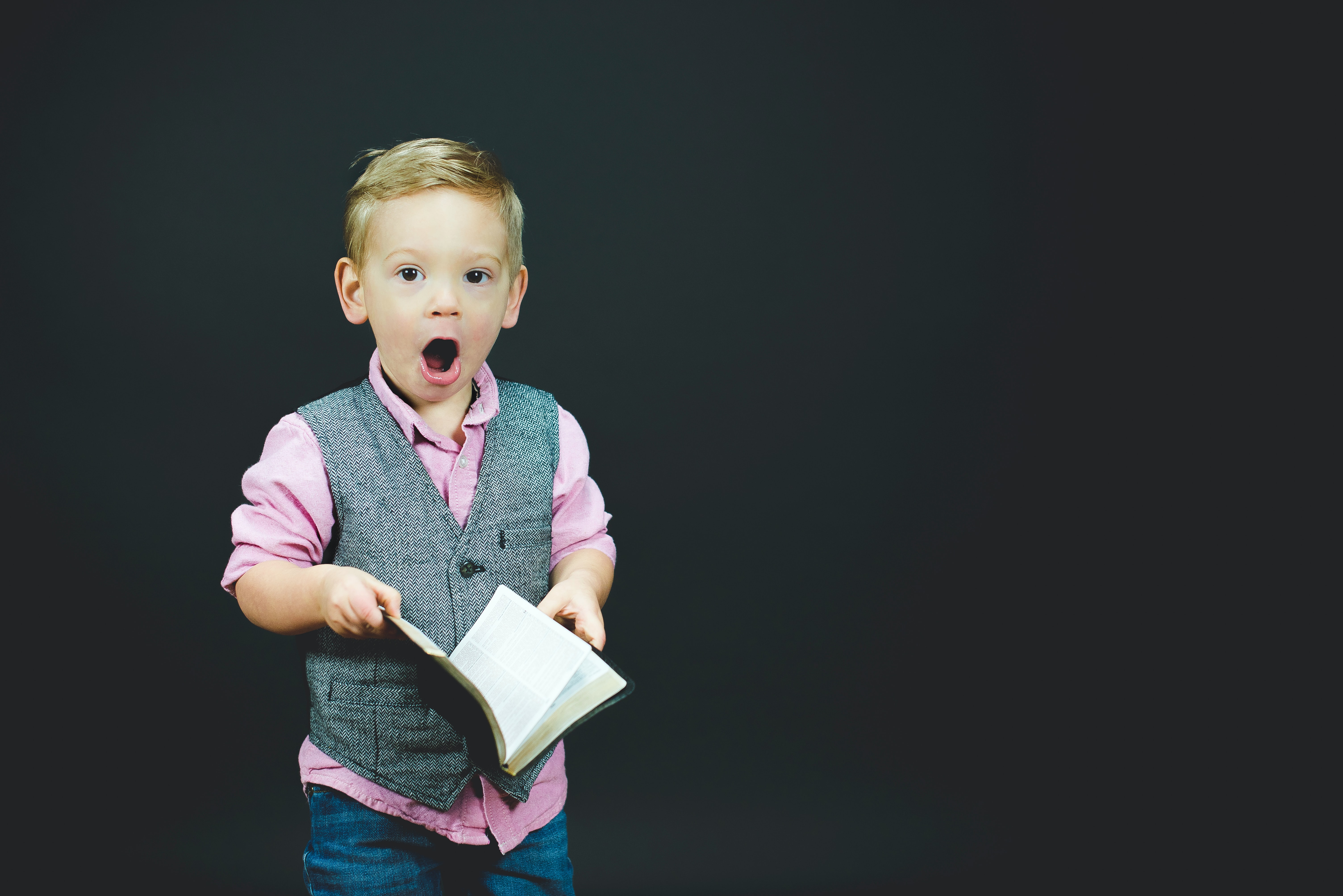 Un enfant avec un livre étonné des idées reçu sur les écoles Montessori
