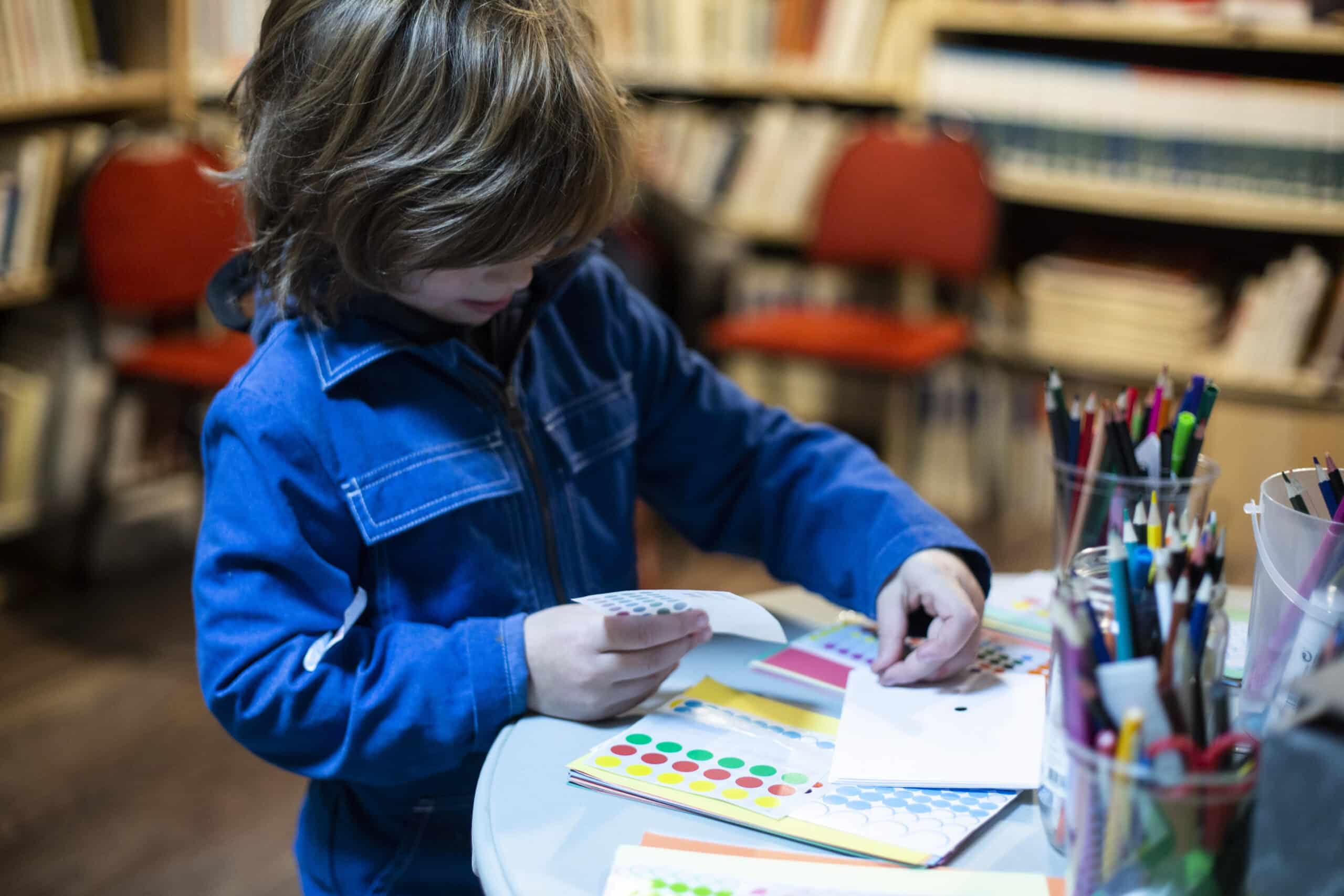 enfant de 7 ans faisant une activité créative à la maison, frais de garde après 6 ans